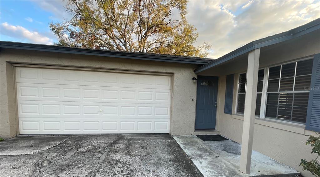 The exterior of a house features a garage, a blue front door, and a concrete driveway — 1008 YORK COURT, BRANDON, FL