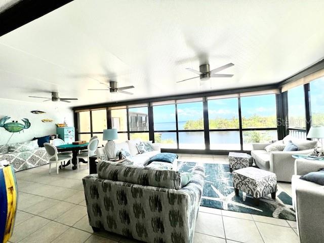 A sunroom with tile floors, ceiling fans, and large windows overlooking a body of water — 3270 SOUTHSHORE DRIVE UNIT 72B, PUNTA GORDA, FL