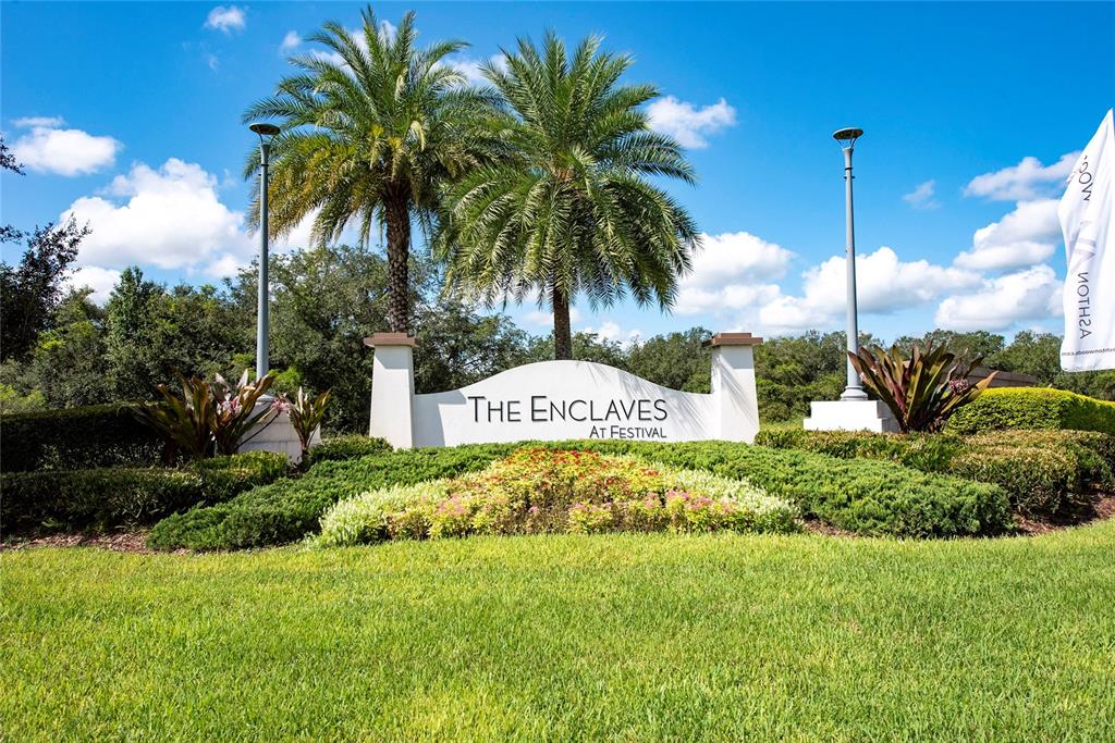 A community entrance sign for The Enclaves at Festival features palm trees and landscaping — 282 CAPTIVA DRIVE, DAVENPORT, FL