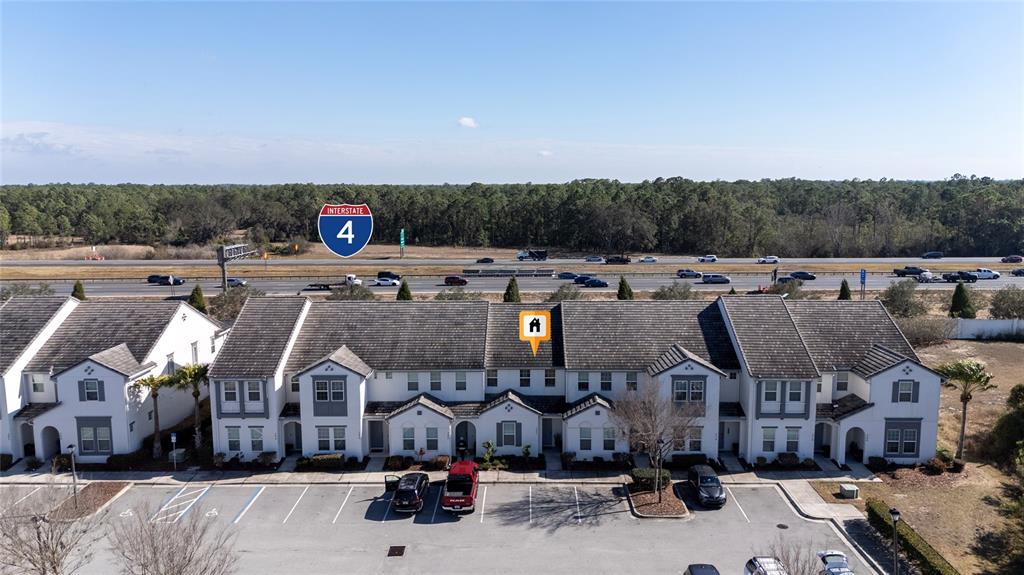 An aerial view of a multi-unit townhouse complex located adjacent to an interstate highway — 282 CAPTIVA DRIVE, DAVENPORT, FL