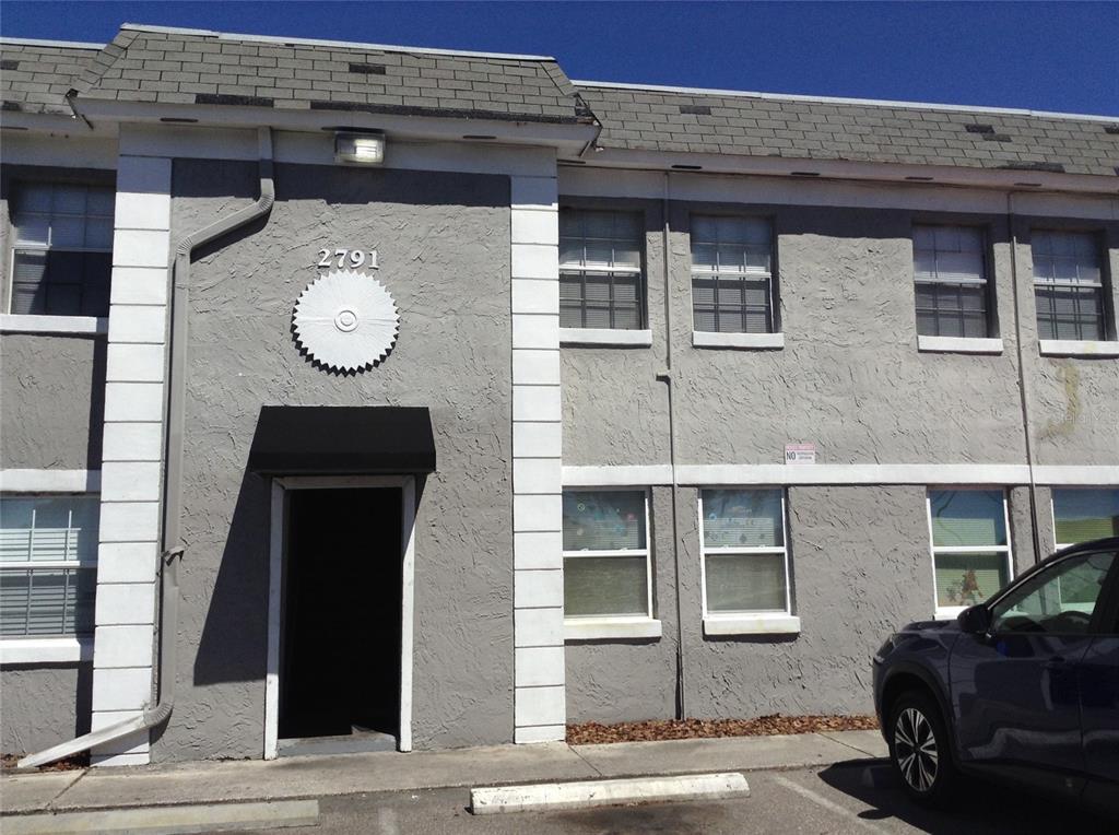 A two-story gray stucco building features a black awning over the entrance and white trim — 2791 L B MCLEOD ROAD UNIT 2791B, ORLANDO, FL
