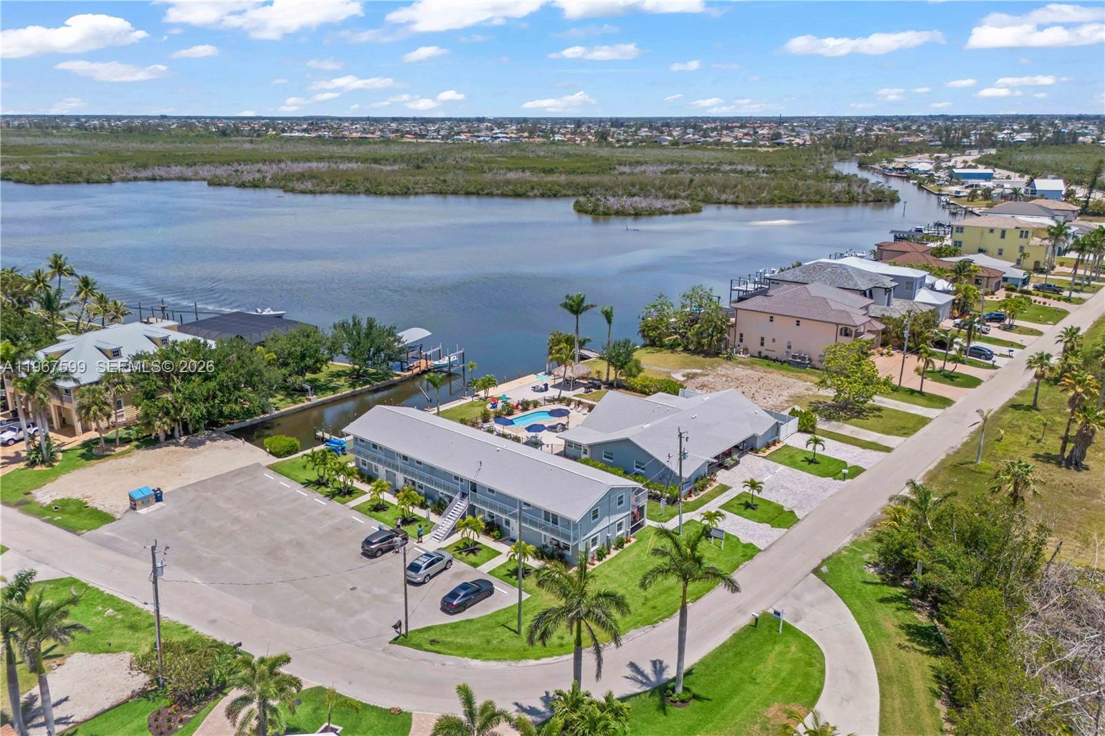 An aerial view shows a multi-unit residential building with a pool near a waterway — 12200/12210 Shoreview DR, Matlacha FL 33993, MATLACHA, FL