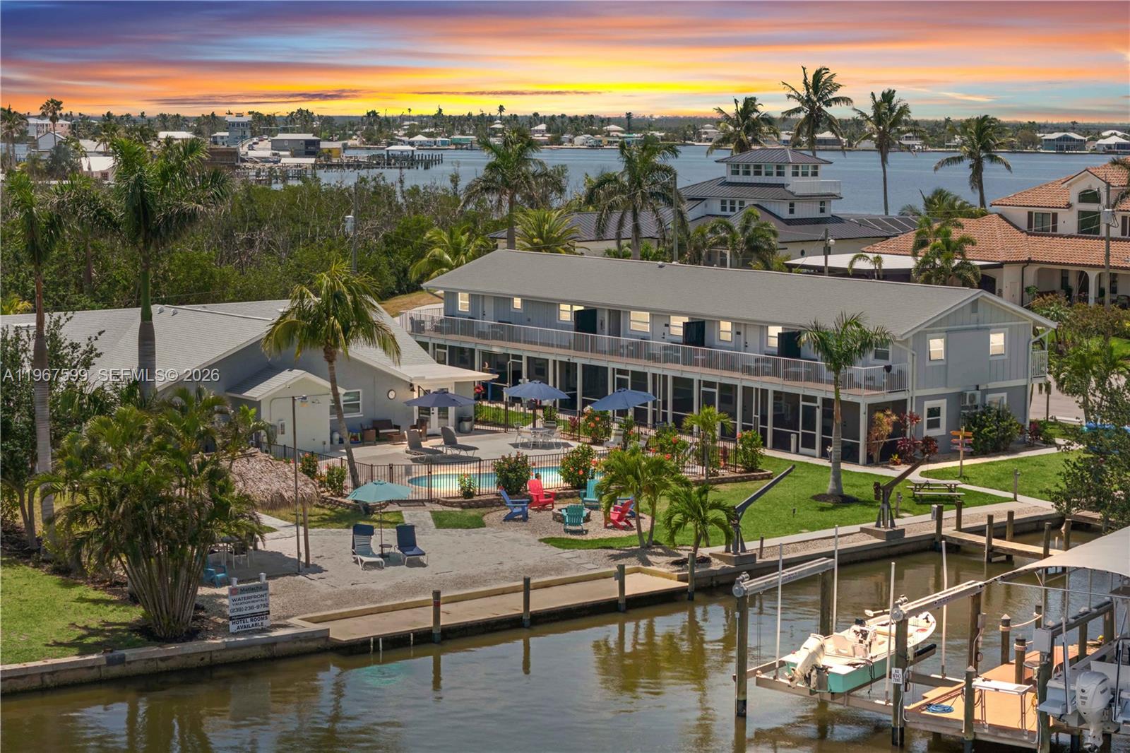 An aerial view shows a waterfront building with a pool, patio, and boat docks — 12200/12210 Shoreview DR, Matlacha FL 33993, MATLACHA, FL