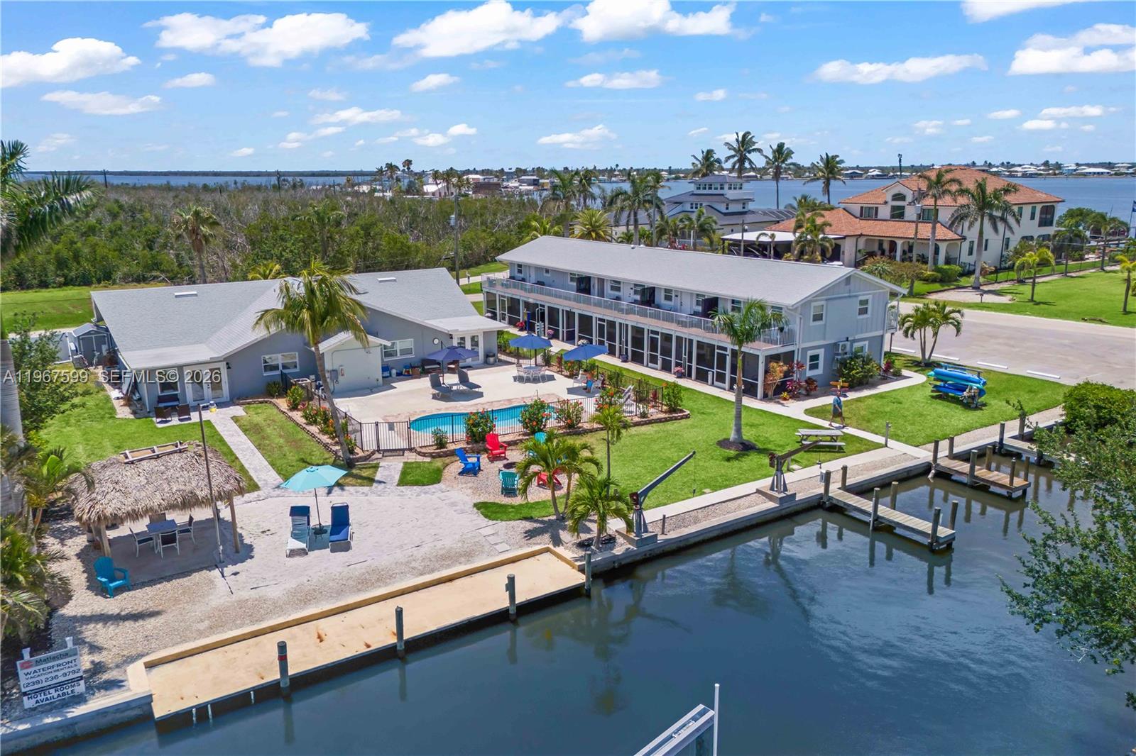 An aerial view shows a waterfront property with a pool, dock, and two-story building — 12200/12210 Shoreview DR, Matlacha FL 33993, MATLACHA, FL