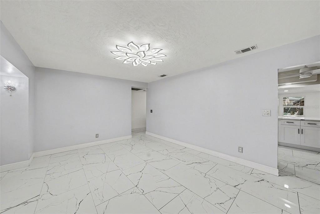 A room with white marble-patterned tile floors, light gray walls, and a decorative ceiling light — 2910 W BURKE STREET, TAMPA, FL