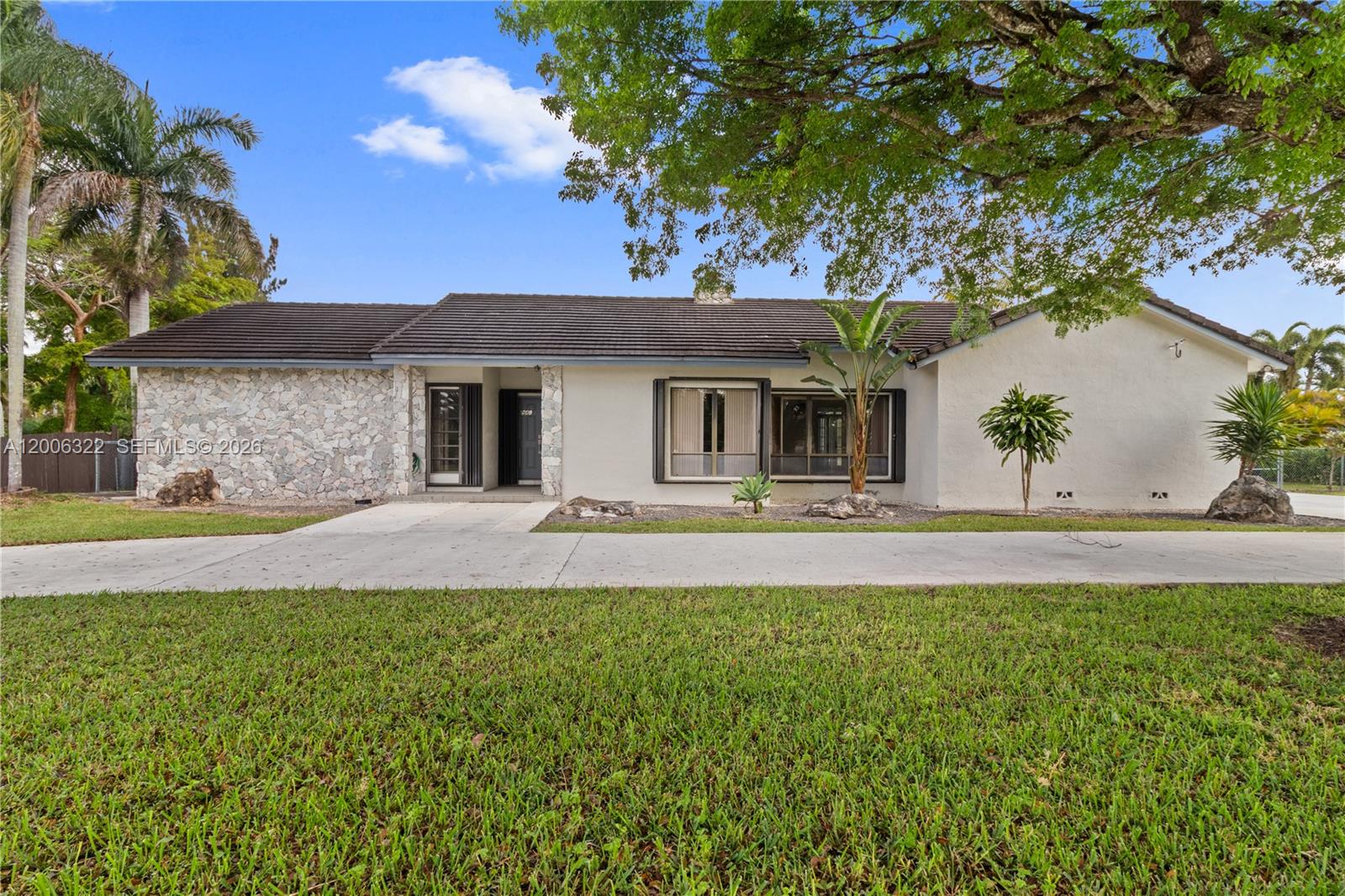 A single-story house features a stone facade, a dark tiled roof, and a concrete driveway — 15941 SW 252nd St, Homestead FL 33031, HOMESTEAD, FL