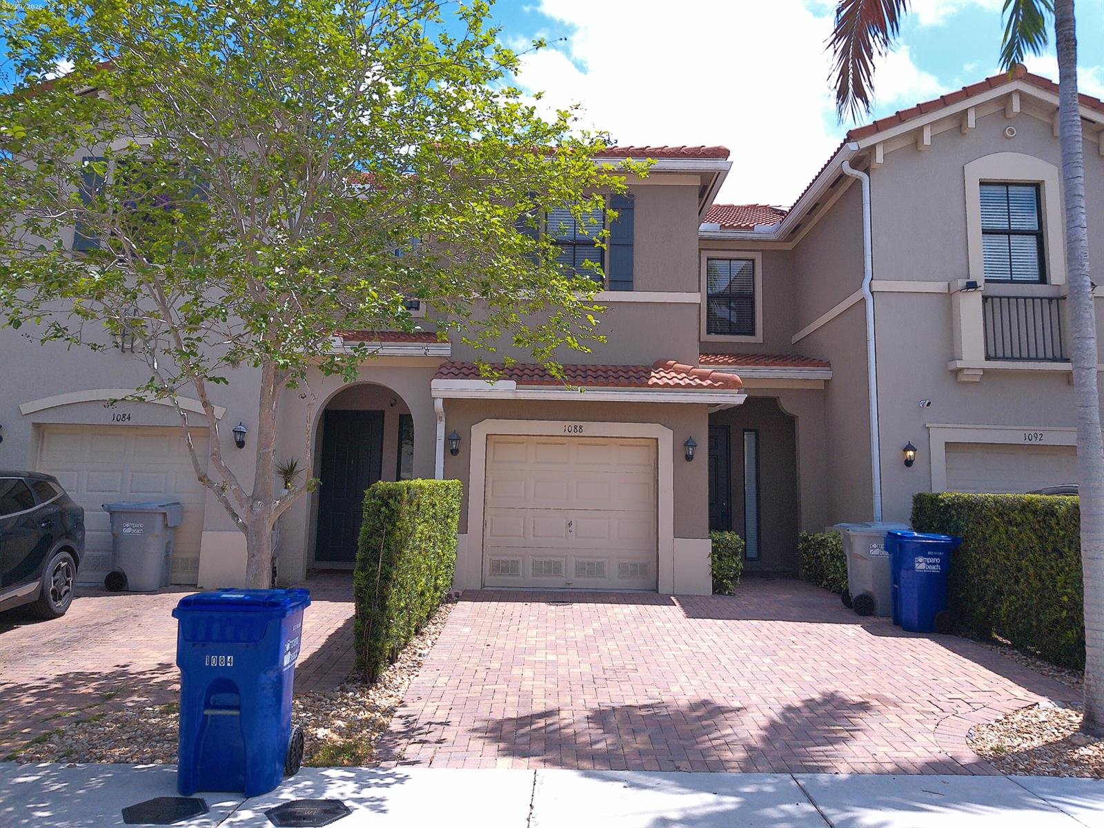 A multi-unit residential building exterior features tan stucco walls, tile roofs, and brick driveways — 1088 NW 33rd Court, Pompano Beach FL 33064, POMPANO BEACH, FL