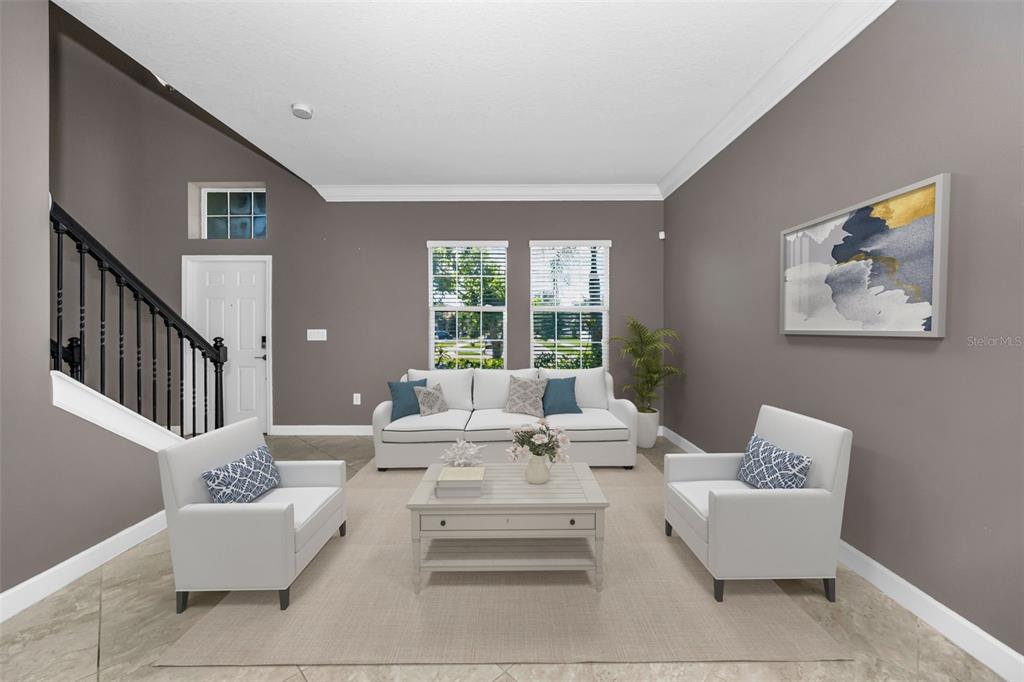 A living room features gray walls, white furniture, a coffee table, and a staircase — 11923 CINNAMON FERN DRIVE, RIVERVIEW, FL