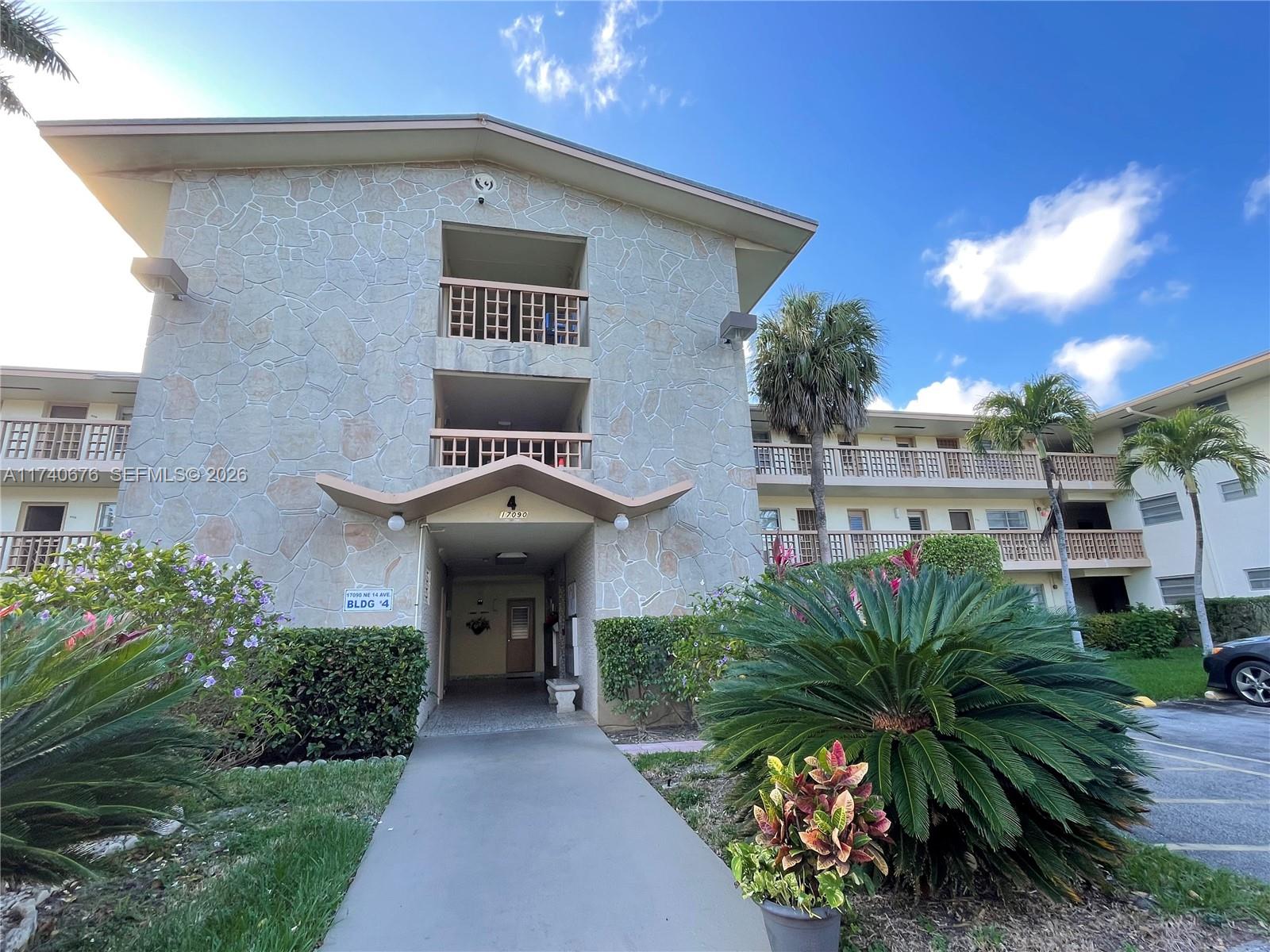 A three-story apartment building features stone veneer siding and a covered ground-level entrance — 17090 NE 14th Ave # 314, Miami FL 33162, MIAMI, FL