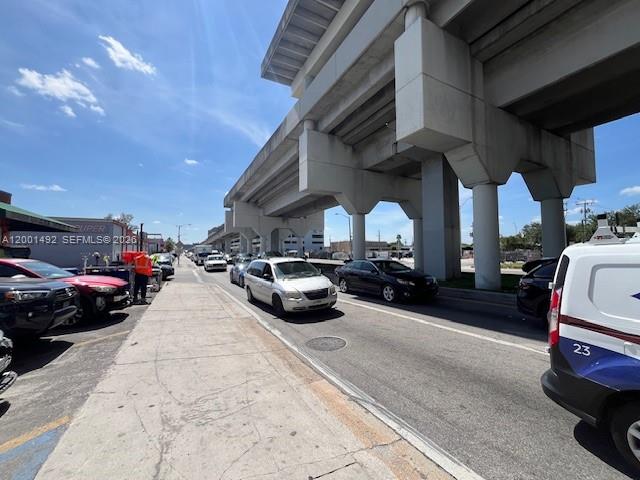 A street-level view shows cars parked and driving under a large concrete highway overpass — 1120 E 25th St, Hialeah FL 33013, HIALEAH, FL