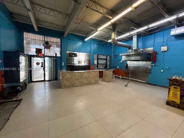 An industrial-style commercial space features blue walls, a service counter, and a stainless steel hood — 1120 E 25th St, Hialeah FL 33013, HIALEAH, FL