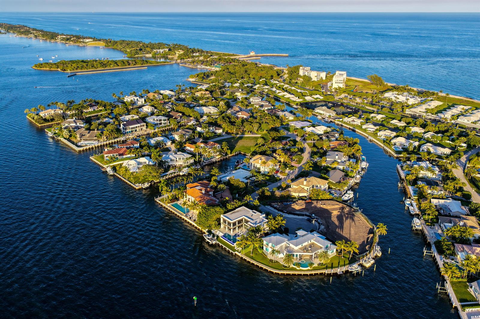 An aerial view shows a vacant, fenced waterfront lot situated between two large residential homes — 92 Island Drive S, Ocean Ridge FL 33435, OCEAN RIDGE, FL