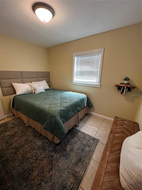 A bedroom features a bed with a green quilt, a headboard, and a floating wall shelf — 138 WOODS ROAD, SAN MATEO, FL