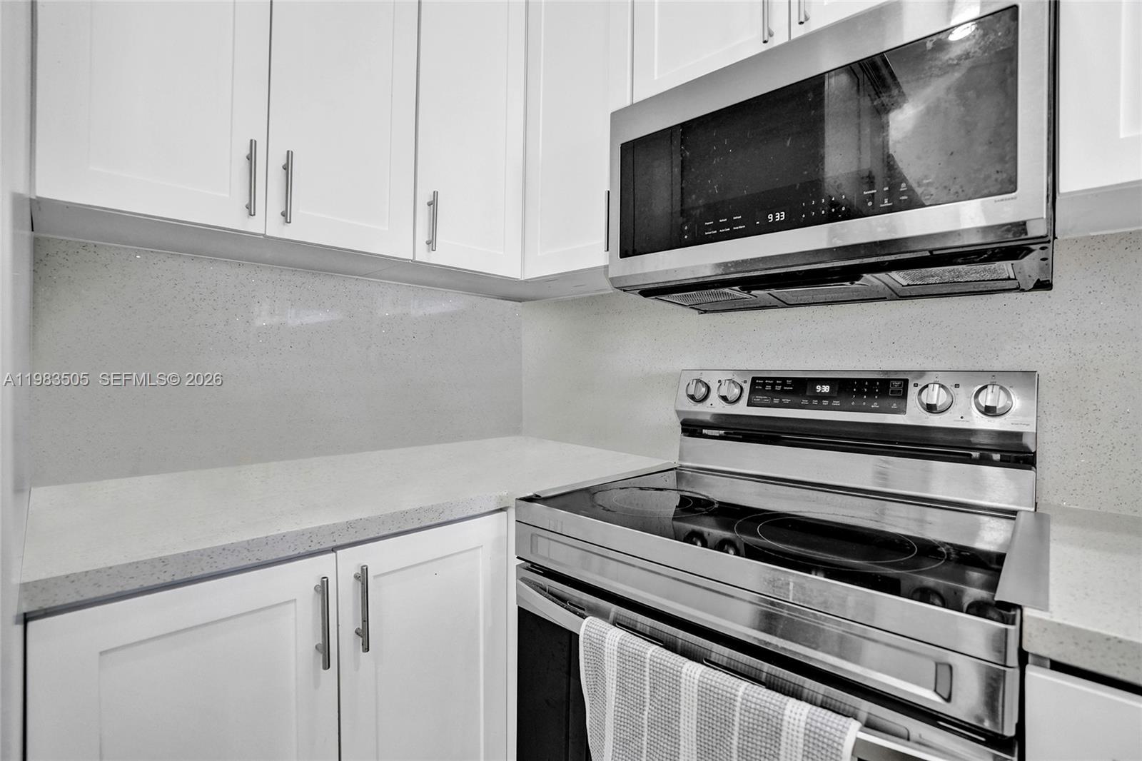 A kitchen features white cabinets, stainless steel appliances, and light-colored quartz countertops — 6405 SW 152nd Cir Pl # 05, Miami FL 33193, MIAMI, FL