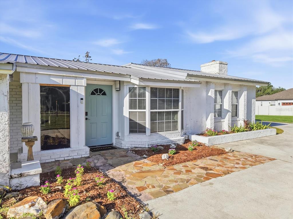 A white house with a light blue front door and a stone walkway — 1113 COLSON ROAD, PLANT CITY, FL
