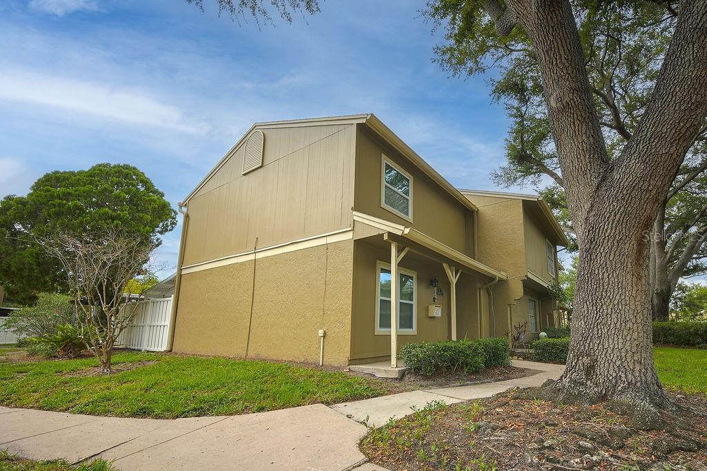 A two-story tan building with a covered entryway and a large tree in the yard — 6902 SOLEDAD COURT, TAMPA, FL