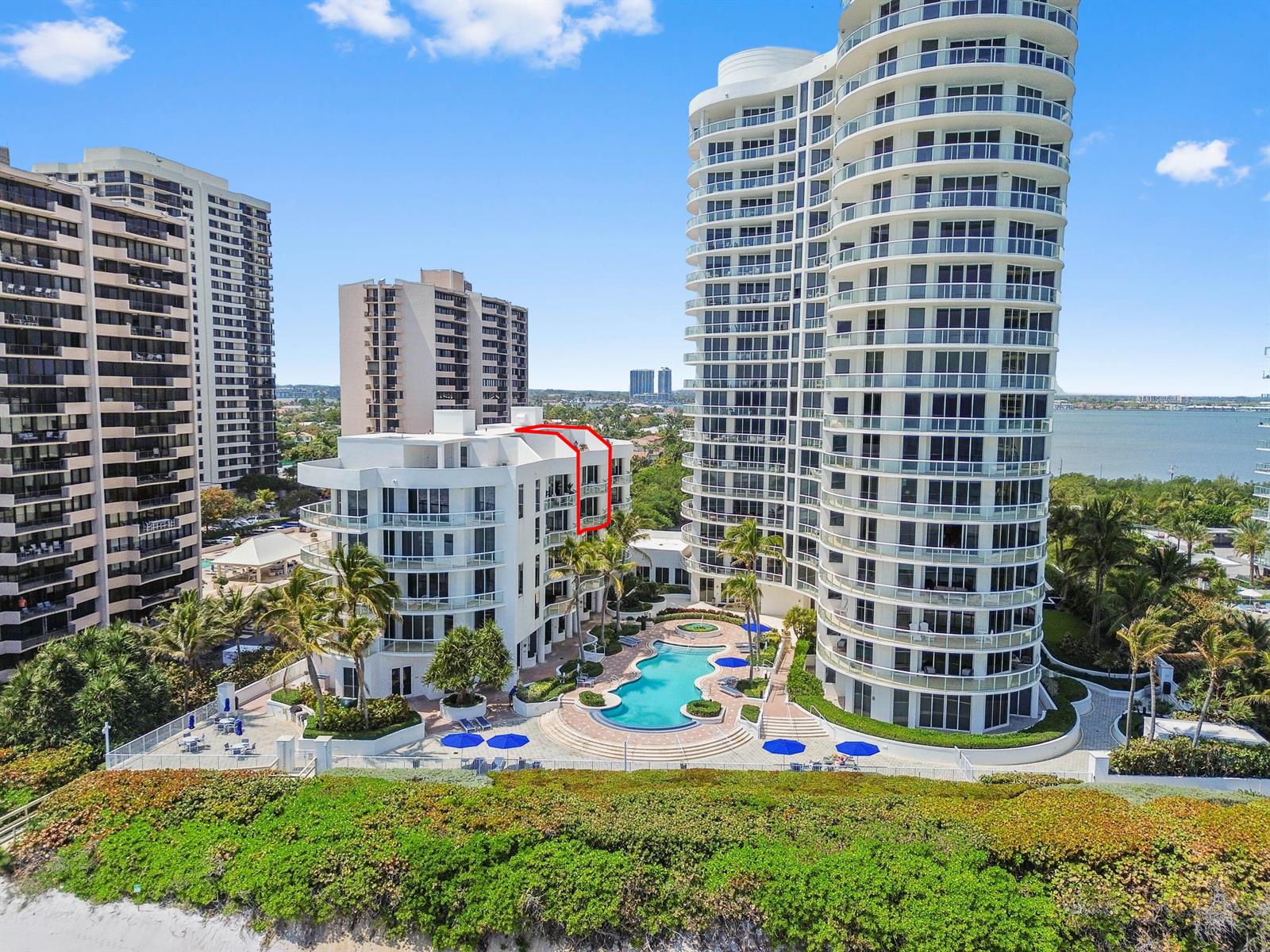 An aerial view shows a white mid-rise building with a red-outlined balcony near a pool — 4600 N Ocean Drive # 605, Riviera Beach FL 33404, RIVIERA BEACH, FL