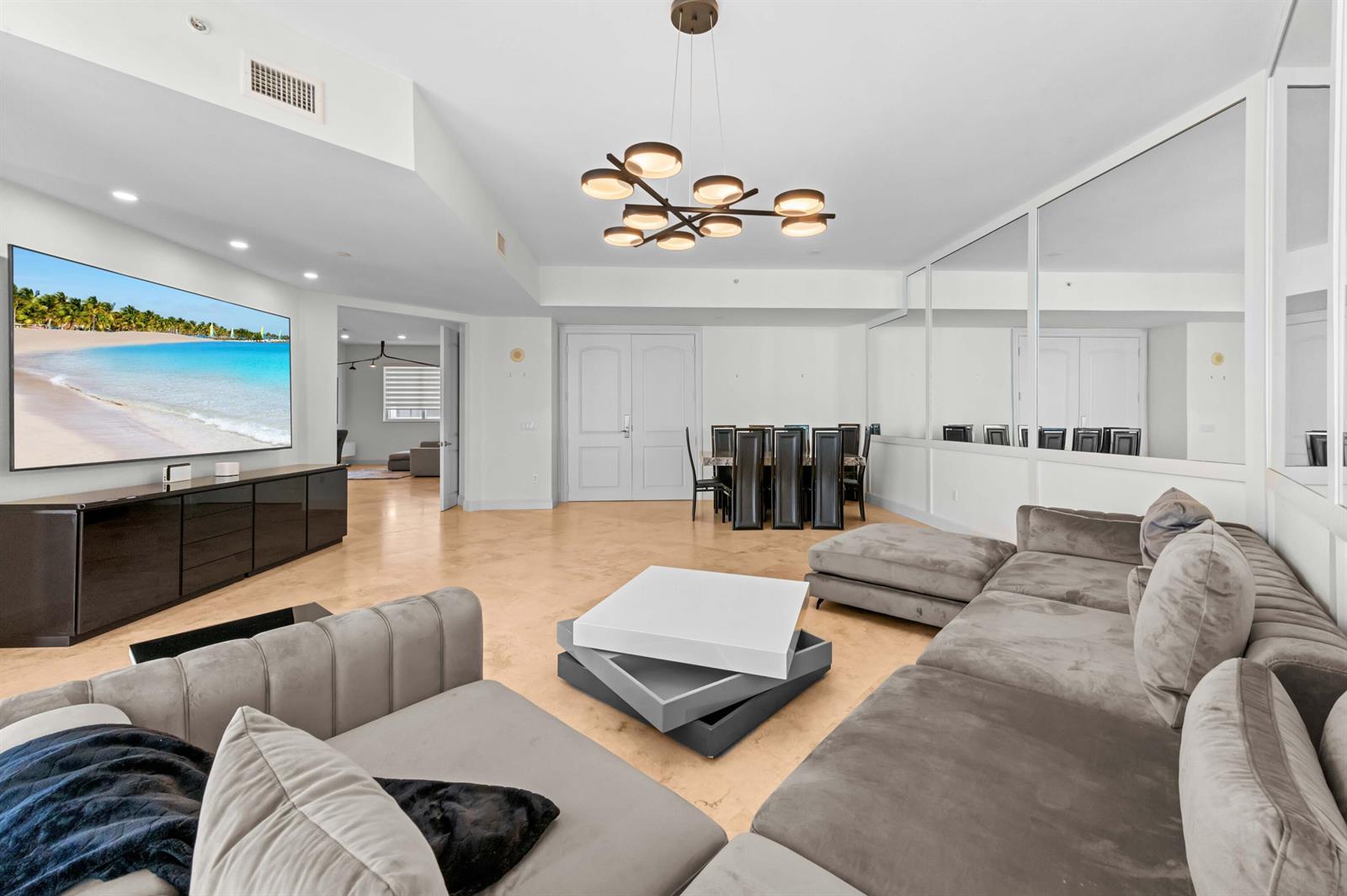 A spacious living room features a large sectional sofa, a television, and a dining area — 4600 N Ocean Drive # 605, Riviera Beach FL 33404, RIVIERA BEACH, FL
