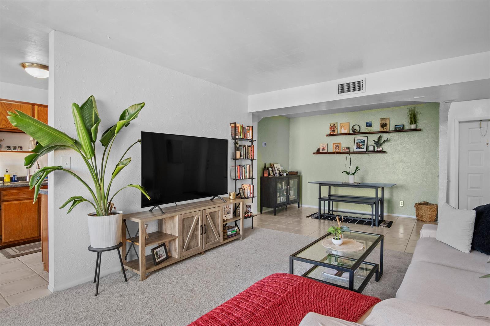 A living room features a television on a wooden stand, a plant, and dining area — 3500 Blue Lake Drive # 503, Pompano Beach FL 33064, POMPANO BEACH, FL