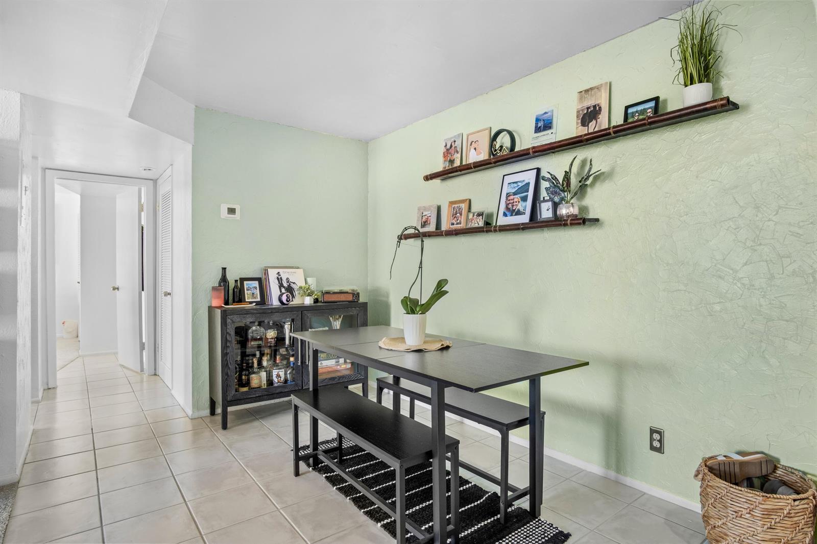 A dining area features a black table with benches, a bar cabinet, and two wall shelves — 3500 Blue Lake Drive # 503, Pompano Beach FL 33064, POMPANO BEACH, FL