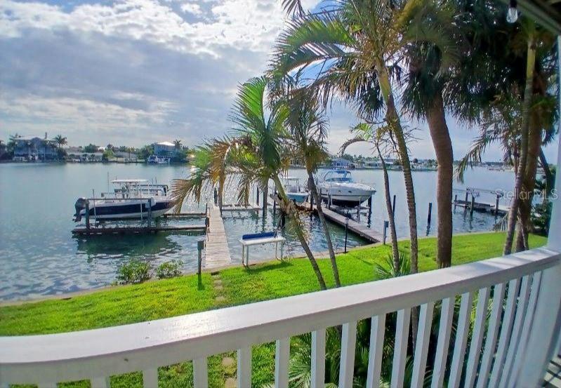 A view of a canal with docked boats from a white wooden balcony — 2505 BAY BOULEVARD UNIT 1, INDIAN ROCKS BEACH, FL
