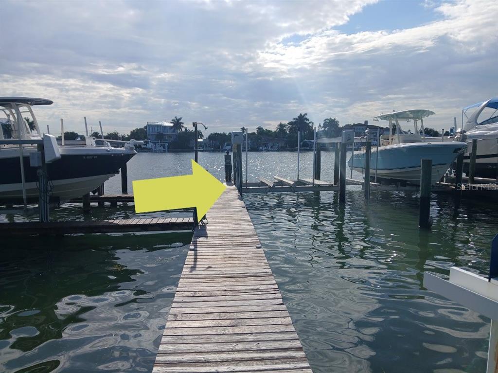 A wooden dock extends into the water between two boat lifts holding boats — 2505 BAY BOULEVARD UNIT 1, INDIAN ROCKS BEACH, FL