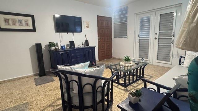 A living room features a blue media console, a glass coffee table, and a rattan chair — PLAYA AZUL OCEAN DRIVE UNIT 748, LUQUILLO, PR