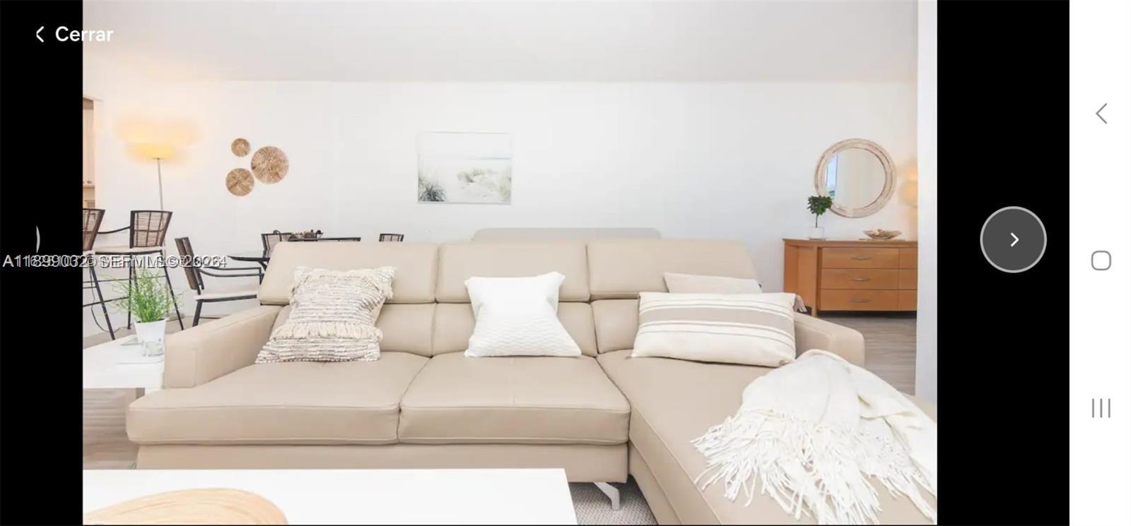 A living room features a beige sectional sofa, a wooden dresser, and wall decor — 2301 Collins Ave # 736, Miami Beach FL 33139, MIAMI BEACH, FL
