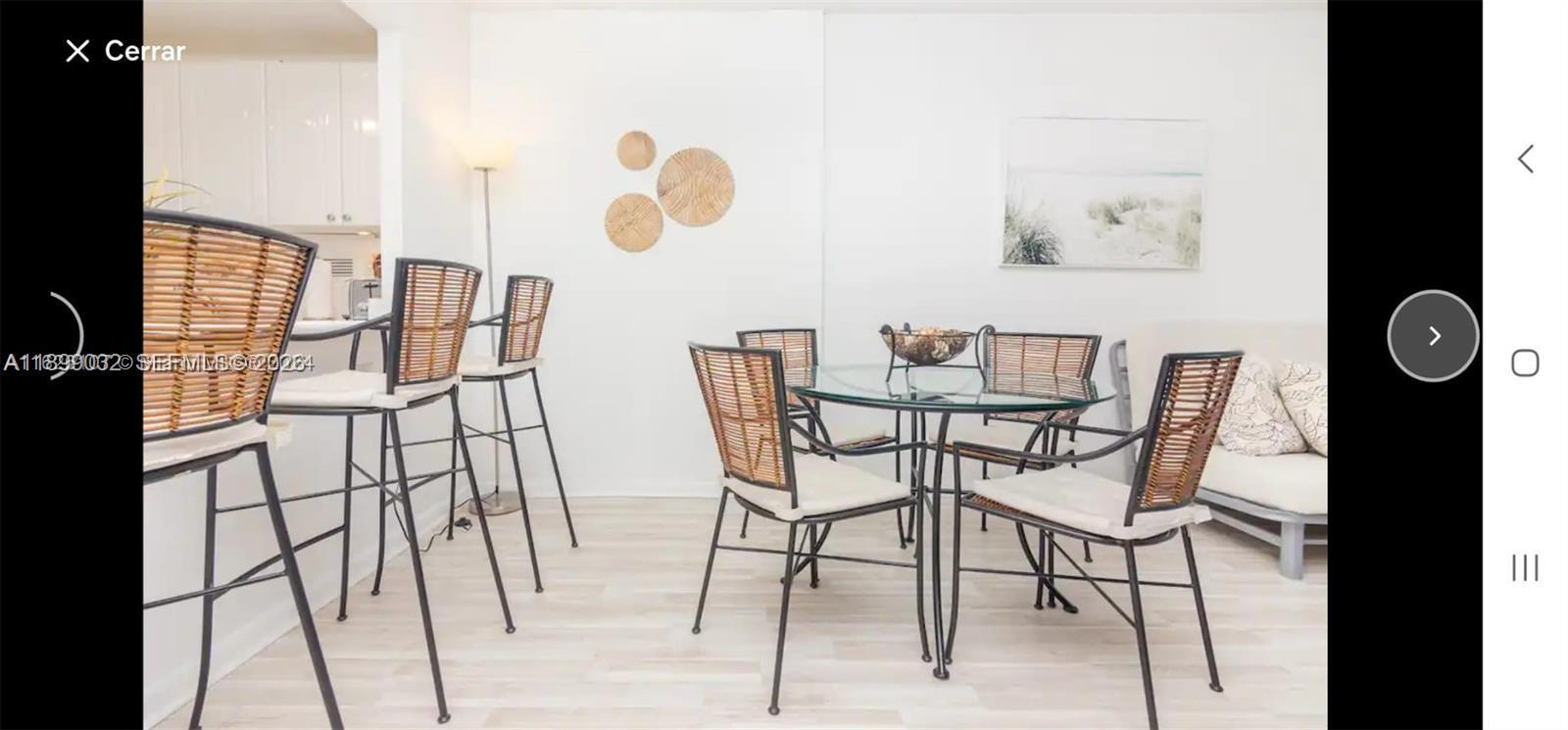 A dining area with a glass-topped table, four chairs, and three bar stools nearby — 2301 Collins Ave # 736, Miami Beach FL 33139, MIAMI BEACH, FL