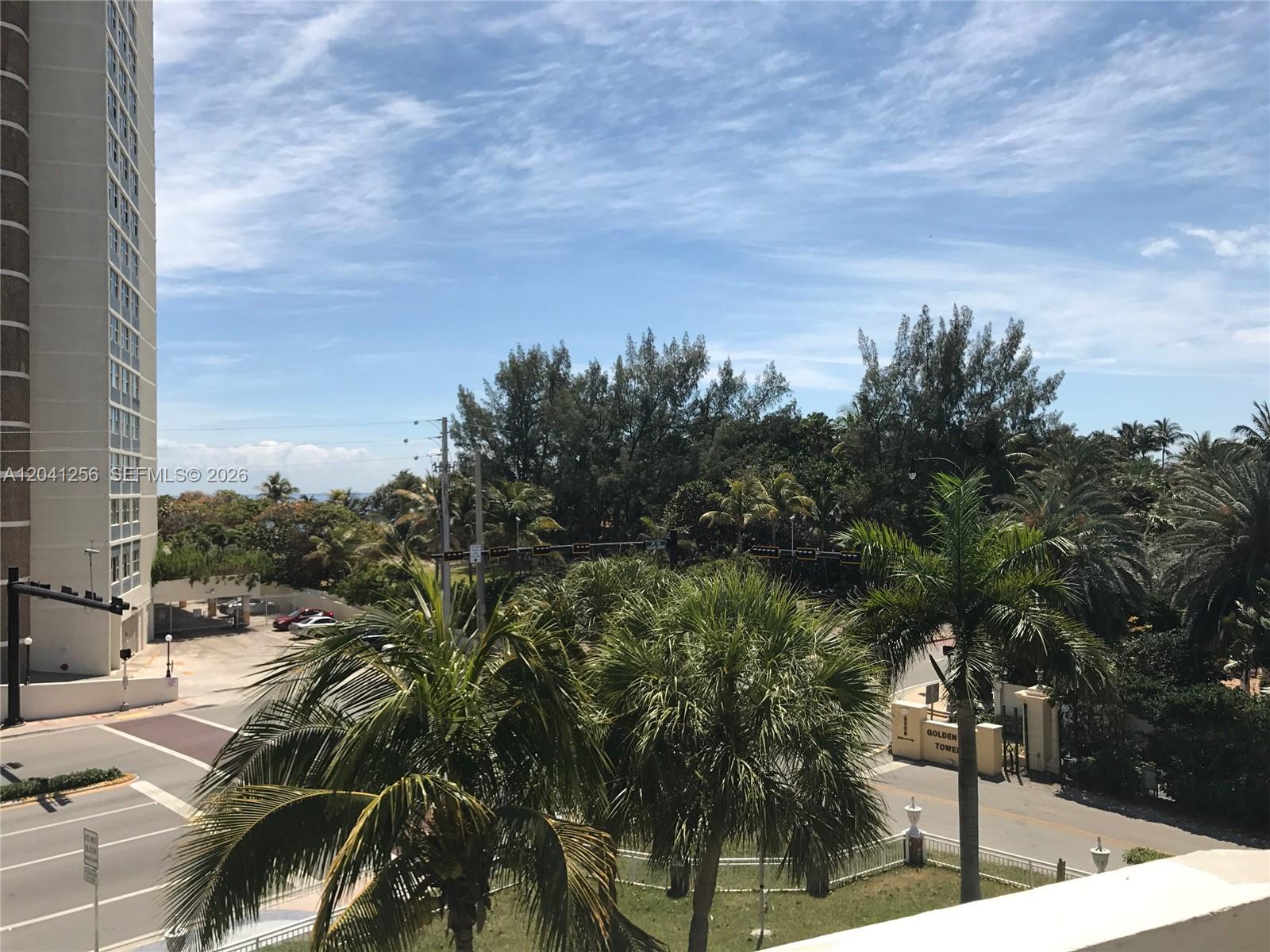 An elevated view shows a tall apartment building, palm trees, and a street intersection — 3199 S Ocean Dr # 402, Hallandale Beach FL 33009, HALLANDALE BEACH, FL