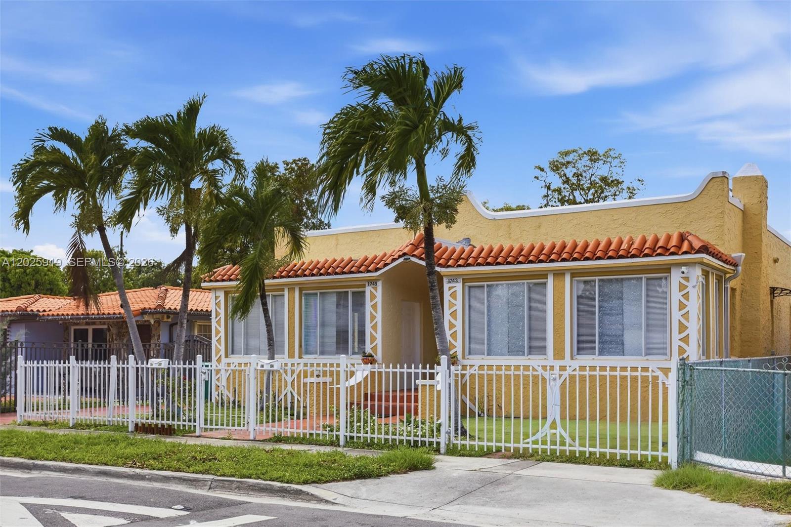 A yellow single-story house with a red tile roof stands behind a white metal fence — 1743 SW 17th St # 1, Miami FL 33145, MIAMI, FL