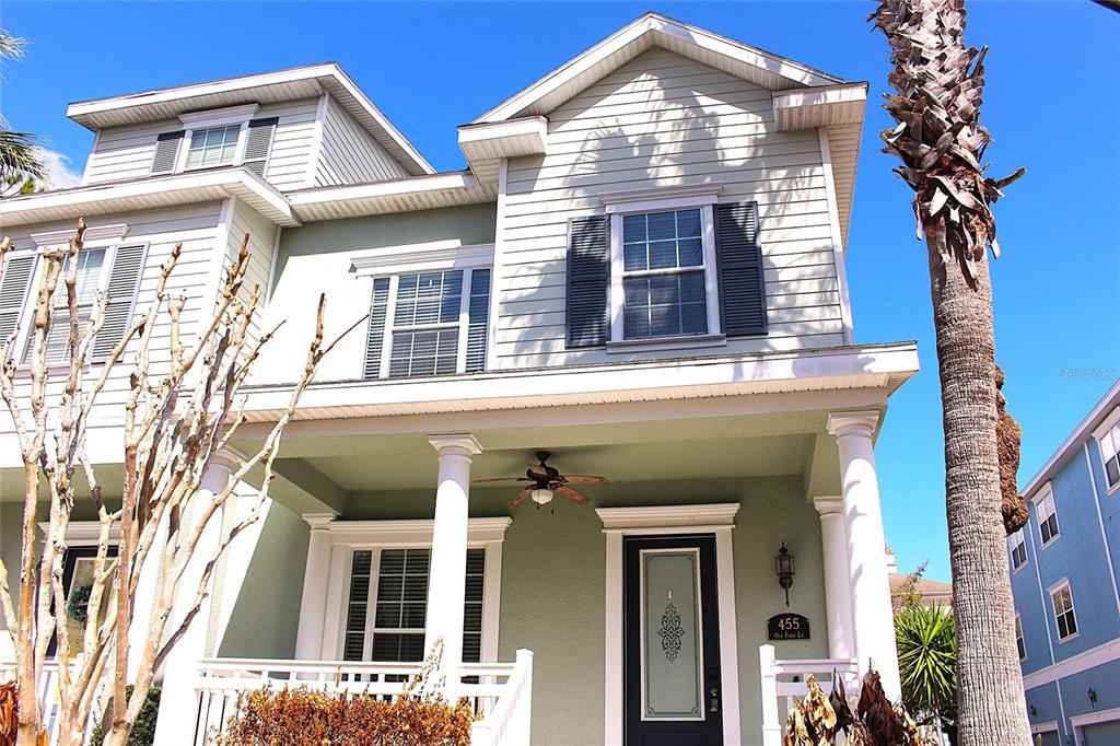 A two-story house with light green siding, a front porch, and a palm tree — 455 OLD FARM LANE, WINTER SPRINGS, FL