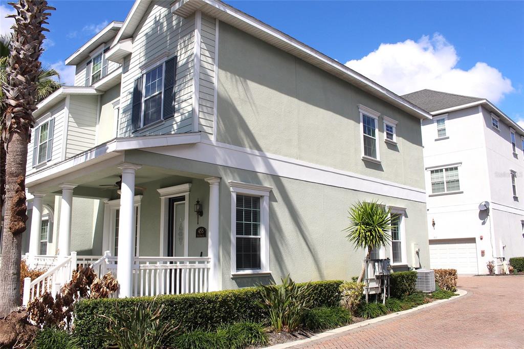 A two-story house with light green stucco siding, a front porch, and a brick driveway — 455 OLD FARM LANE, WINTER SPRINGS, FL