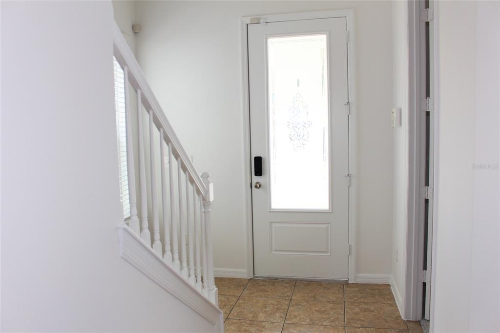 An entryway features a white front door with a decorative glass insert and tiled flooring — 455 OLD FARM LANE, WINTER SPRINGS, FL