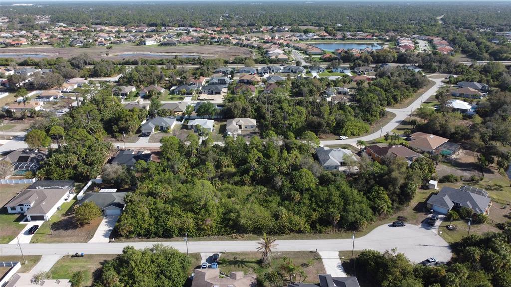 An aerial view shows a vacant, wooded residential lot surrounded by suburban houses and streets — Lot's  36 & 37 OMEGA COURT, NORTH PORT, FL