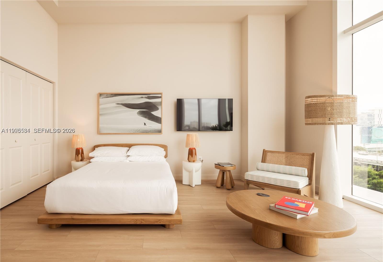 A modern bedroom features a platform bed, a seating area, and a wall-mounted television — 275 SW 6th St # 502, Miami FL 33130, MIAMI, FL