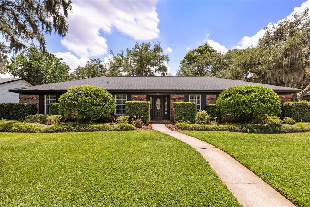 A single-story brick house with a dark roof, front walkway, and manicured landscaping — 504 TIVOLI COURT, ALTAMONTE SPRINGS, FL