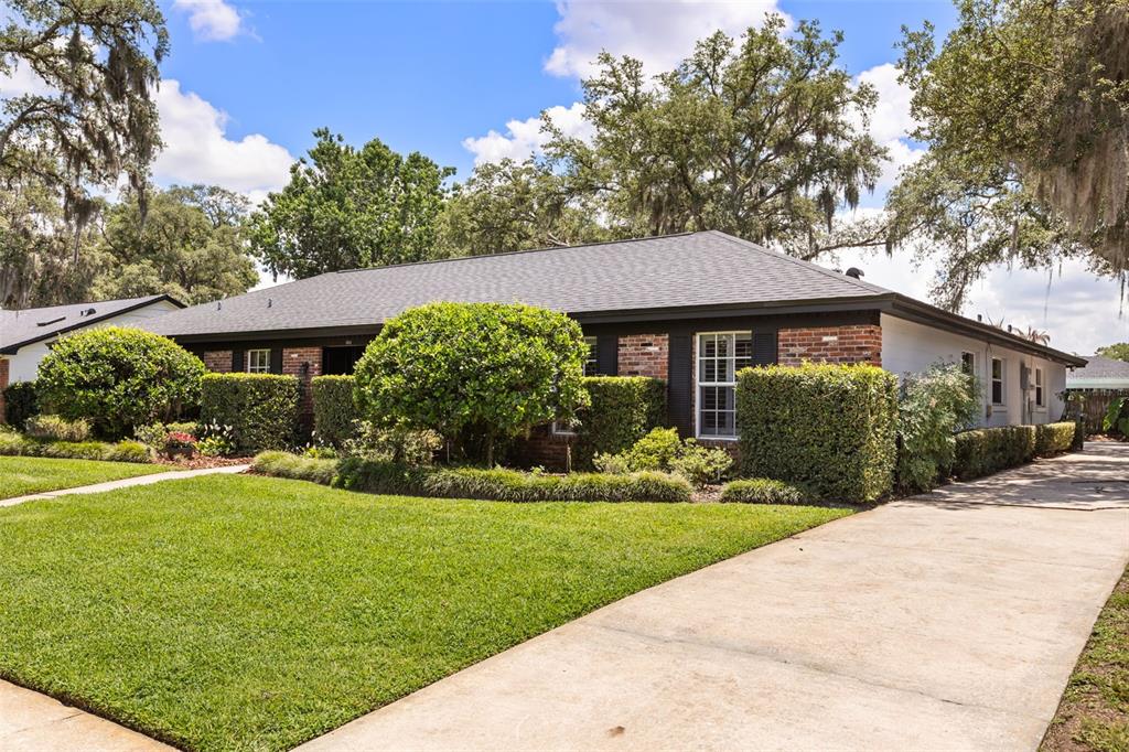 A single-story brick house with a dark roof, manicured hedges, and a concrete driveway — 504 TIVOLI COURT, ALTAMONTE SPRINGS, FL