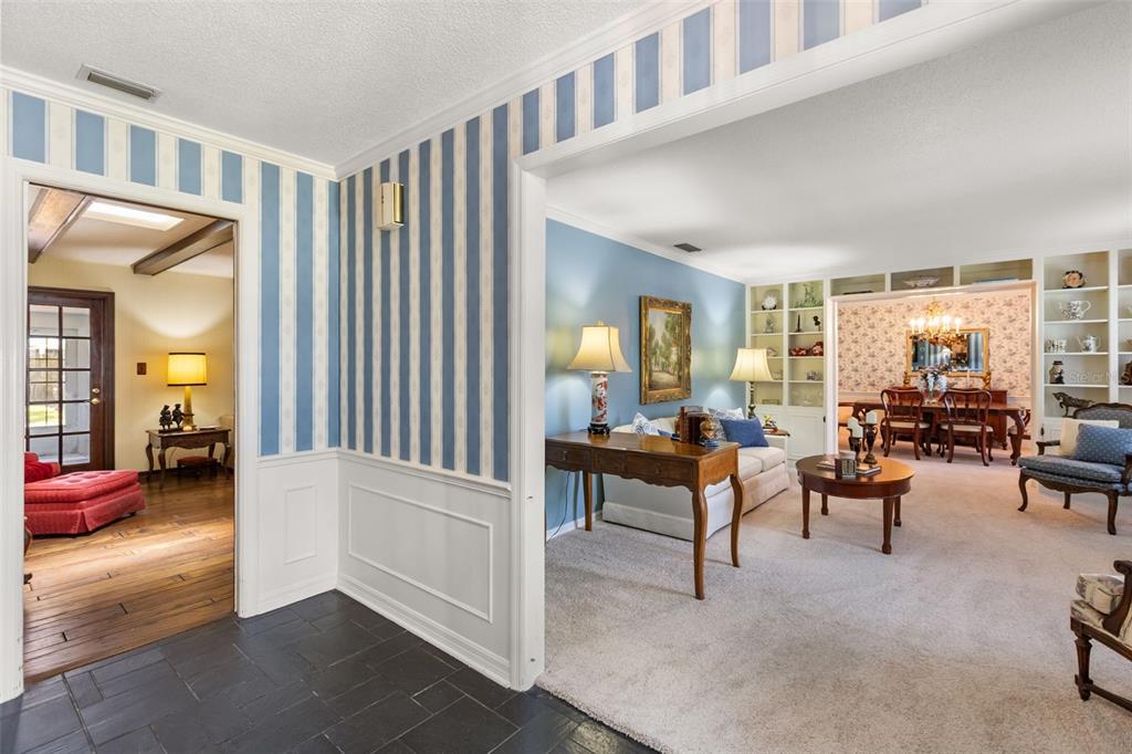 A view from a tiled foyer into a living room with blue walls and carpeting — 504 TIVOLI COURT, ALTAMONTE SPRINGS, FL