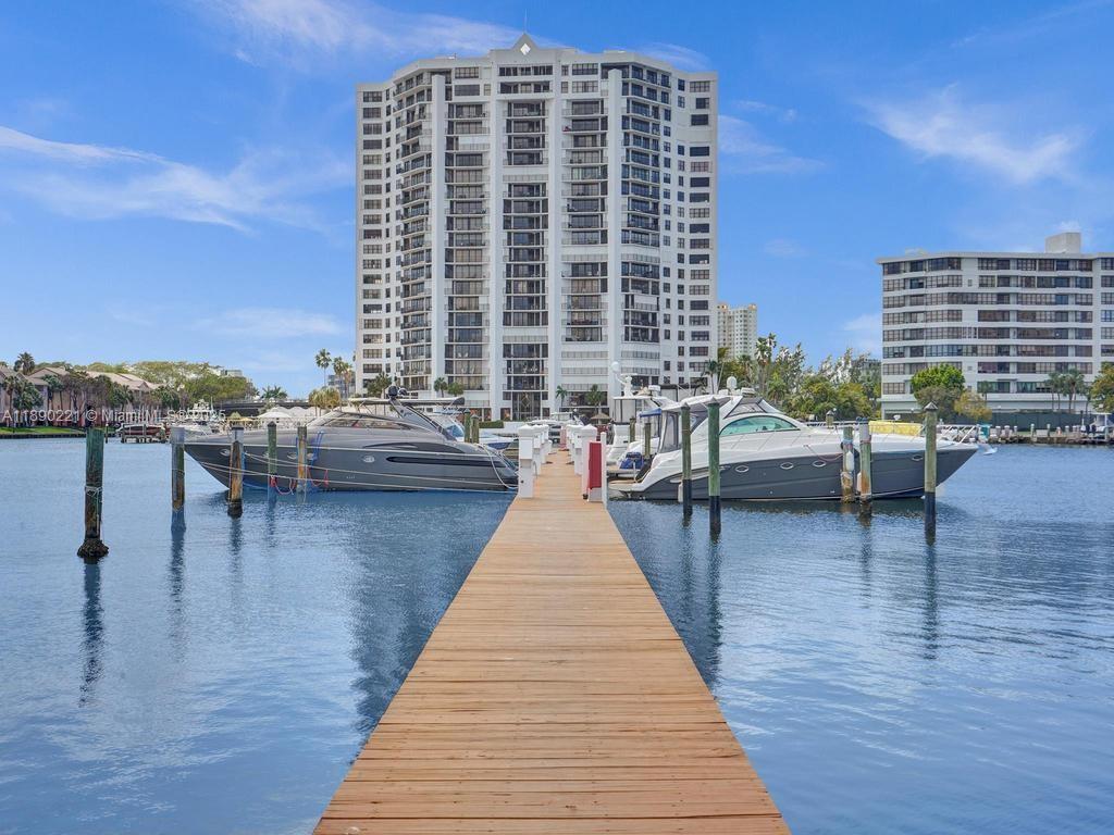 A wooden dock extends toward two yachts moored in front of a tall residential building — 2667 S Parkview Dr, Hallandale Beach FL 33009, HALLANDALE BEACH, FL