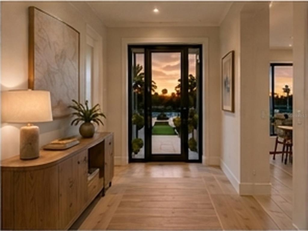 A foyer features light wood flooring, a wooden console table, and a glass-paneled front door — 15148 INGRAHAM BOULEVARD, PORT CHARLOTTE, FL