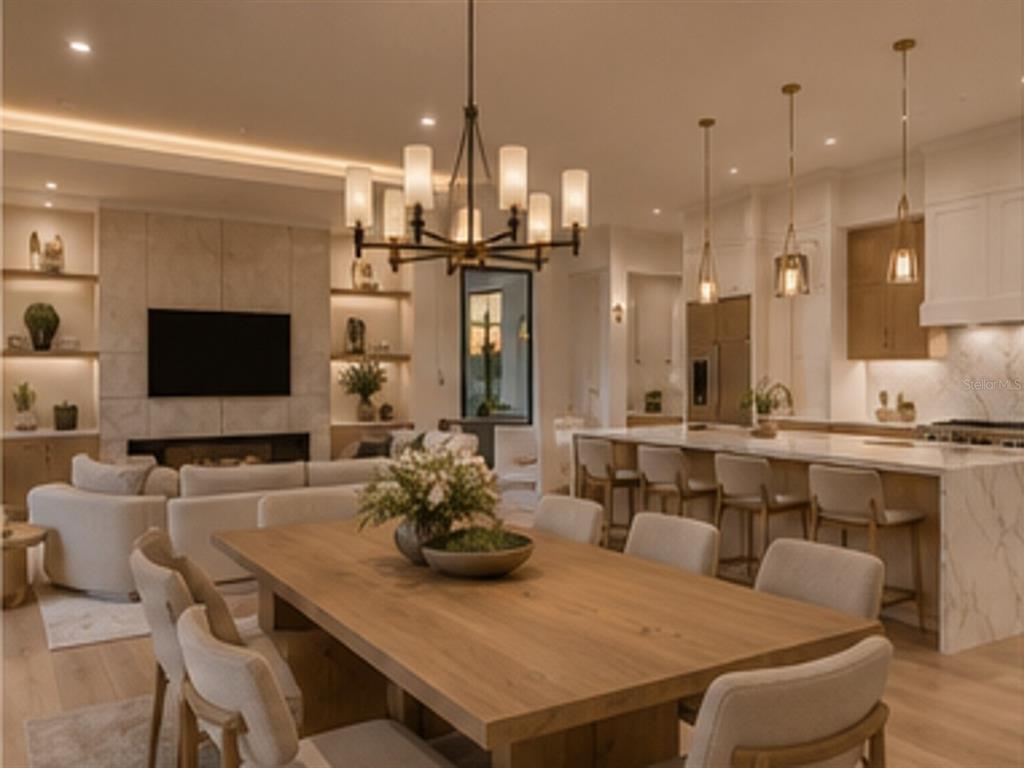 An open-concept living and dining area features a stone fireplace, wood table, and kitchen island — 15148 INGRAHAM BOULEVARD, PORT CHARLOTTE, FL
