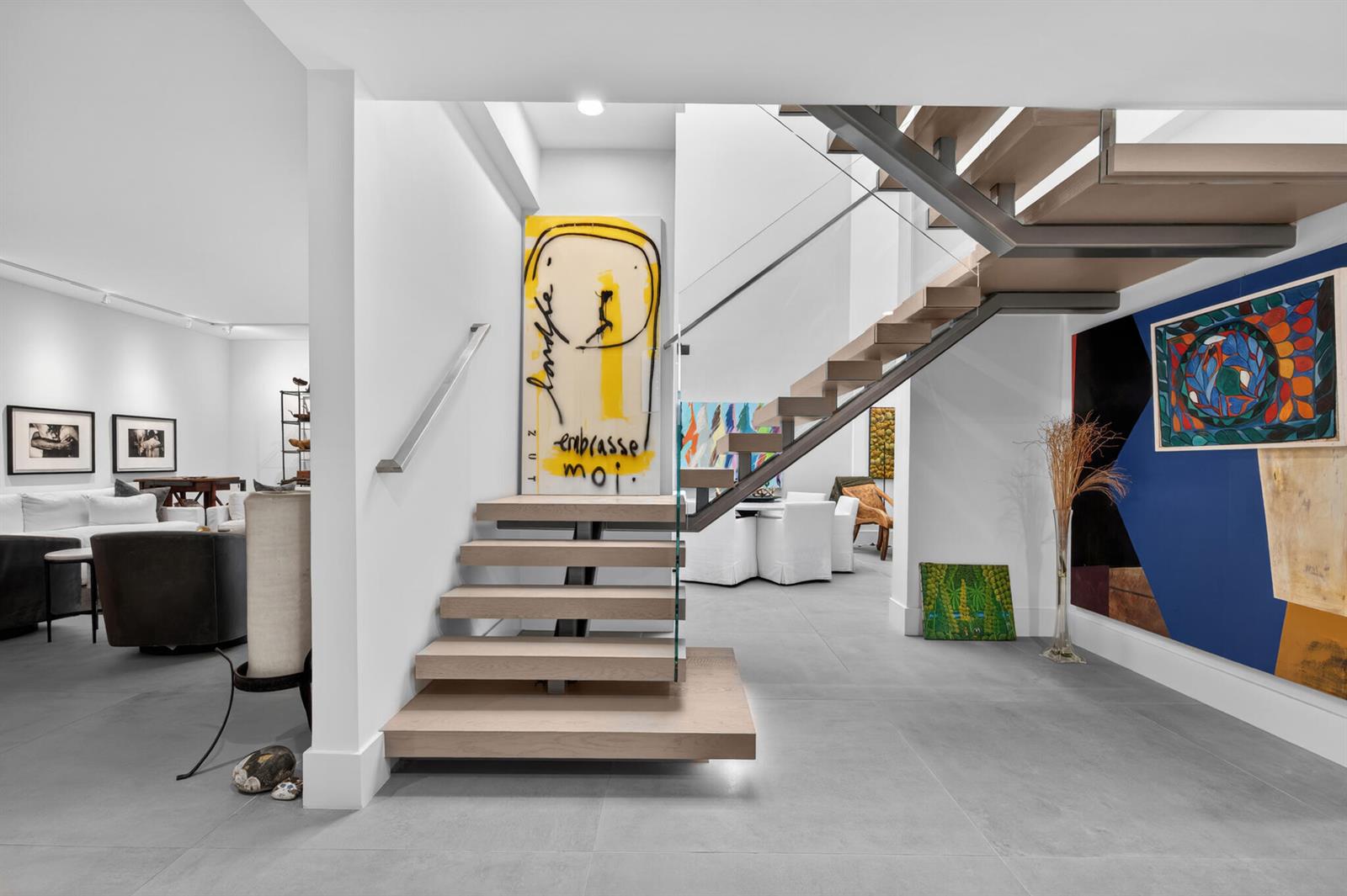 A modern staircase with light wood treads and a glass railing sits in a white foyer — 423 Chilean Avenue, Palm Beach FL 33480, PALM BEACH, FL