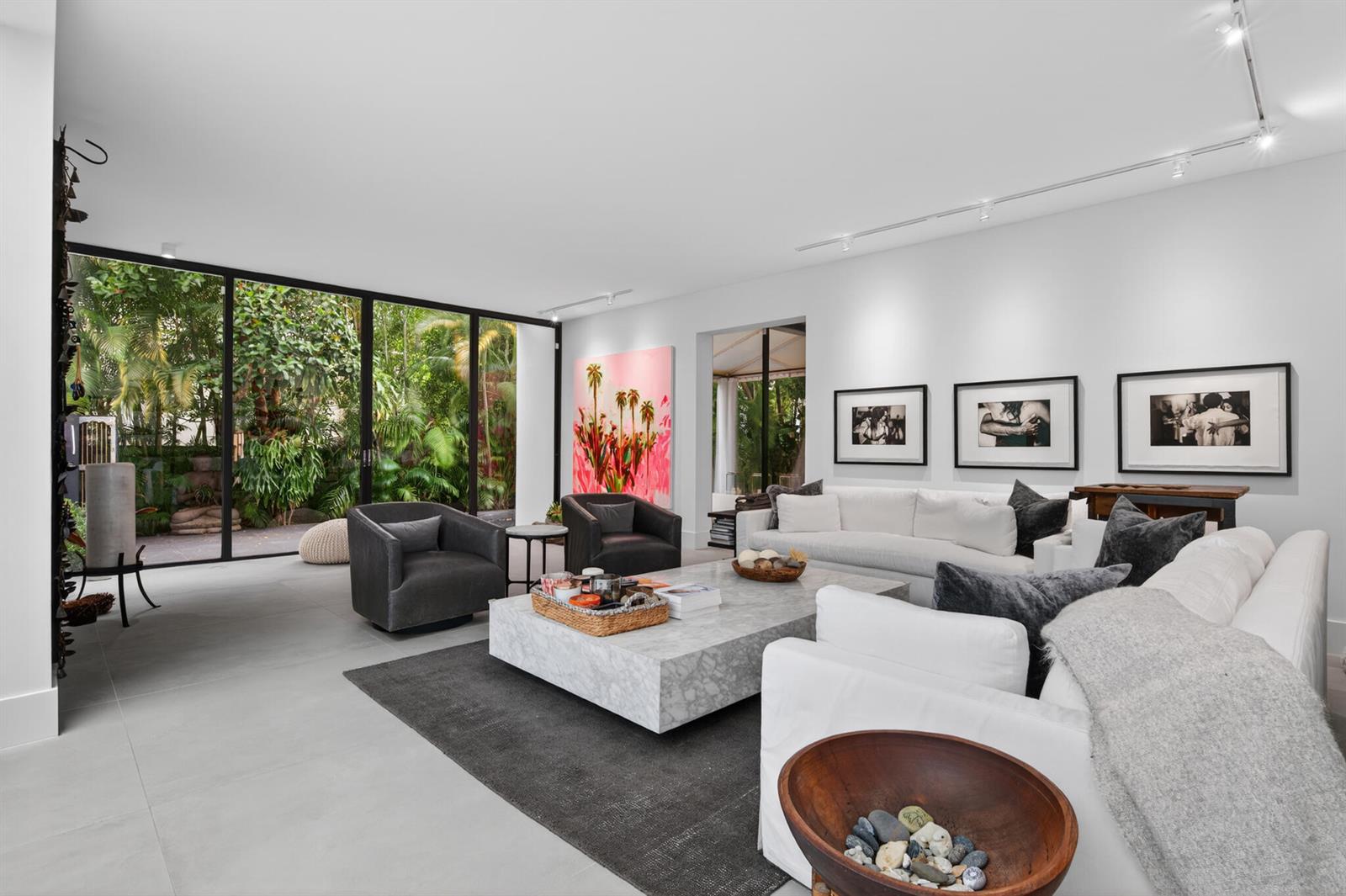 A modern living room features white sofas, a marble coffee table, and floor-to-ceiling glass doors — 423 Chilean Avenue, Palm Beach FL 33480, PALM BEACH, FL