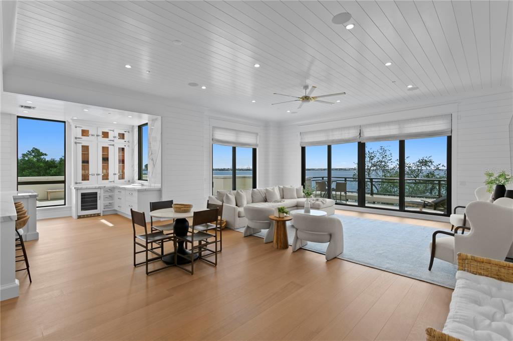 A bright, open-concept living and dining area features light wood floors and waterfront views — 2103 BAYSHORE BOULEVARD UNIT 504, TAMPA, FL