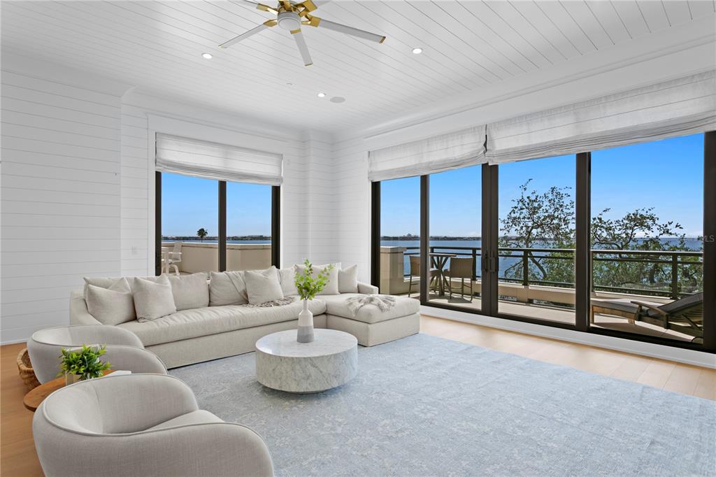 A bright living room features white shiplap walls, a sectional sofa, and large windows overlooking water — 2103 BAYSHORE BOULEVARD UNIT 504, TAMPA, FL
