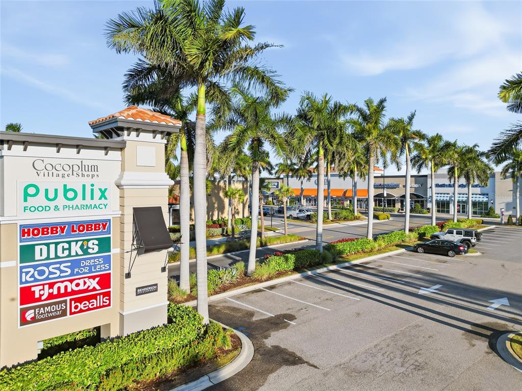 A shopping center sign stands in front of a parking lot with palm trees — LOT 3 LONGWELL LANE, NORTH PORT, FL