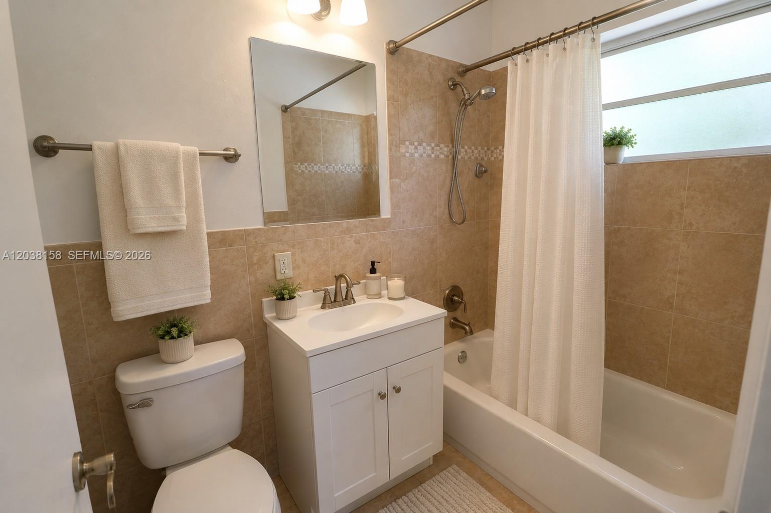 A bathroom features a white vanity, a toilet, and a tiled shower-tub combination — 8025 SW 62nd Pl, Miami FL 33143, MIAMI, FL