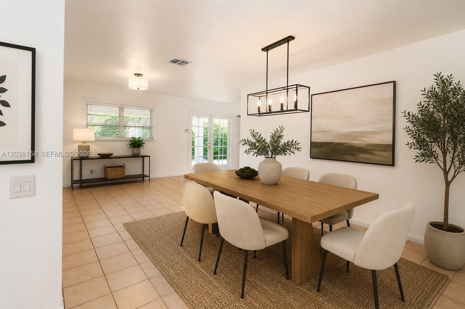 A dining room features a wooden table, six chairs, a pendant light, and tile flooring — 8025 SW 62nd Pl, Miami FL 33143, MIAMI, FL