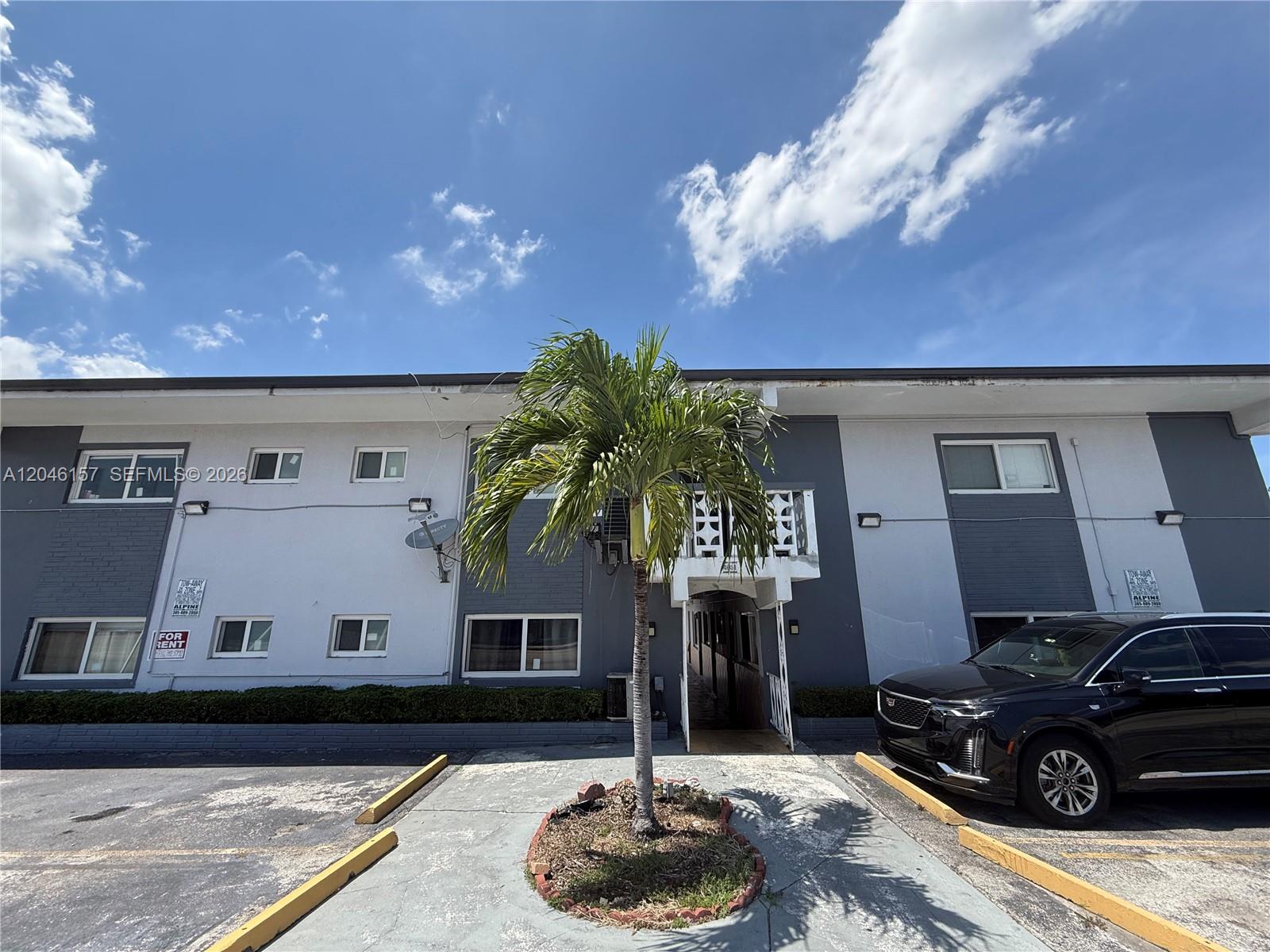 A two-story apartment building exterior features a central palm tree and a parked black SUV — 4651 W Flagler St # 36, Miami FL 33134, MIAMI, FL